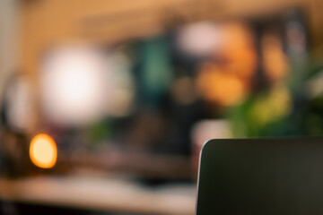 A warm and cozy desk setup featuring triple monitors, notebook, microphone, and green plants, styled in a minimalist Japanese aesthetic for creative work.