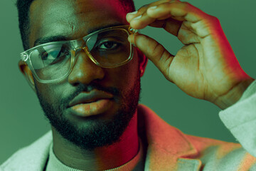 Stylish young man wearing glasses with colorful background, showcasing confidence and charisma in a...