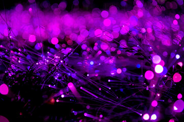 Abstract lights and bokeh form of purple fiber optics glow in a surreal night field