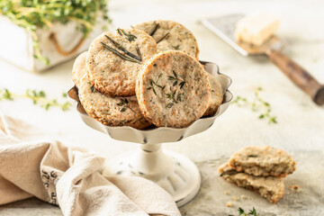 Shortbread cheese cookies with aromatic herbs on rustic textured background. Savory parmesan cookies for party