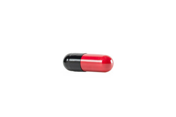 Macro of a red and black pharmaceutical capsule. This single dose of medicine or antibiotic drug is for medical treatment and healthcare concepts. isolated on white background with clipping path.