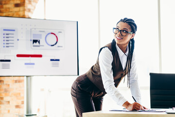 Professional businesswoman presenting data analysis in modern office with a confident smile and...