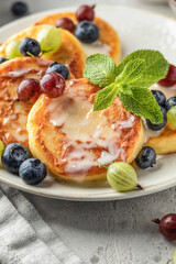 Cottage cheese pancakes with berries and condensed milk close up. Homemade dessert syrniki for healthy breakfast