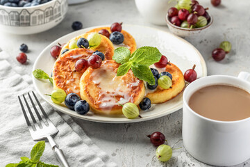 Cottage cheese pancakes with berries and condensed milk. Homemade dessert syrniki for healthy...