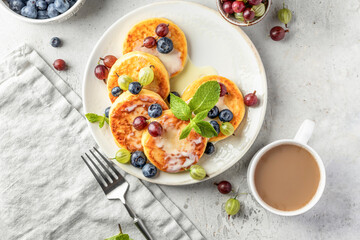 Cottage cheese pancakes with berries and condensed milk top view. Homemade dessert syrniki for healthy breakfast
