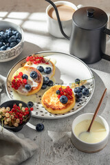 Cottage cheese pancakes with berries and condensed milk. Homemade dessert syrniki for healthy...