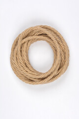A neatly coiled length of electrical cable, wrapped in natural jute twine, is presented on a plain...