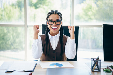 Professional businesswoman celebrating success in her office showcasing strong professional...