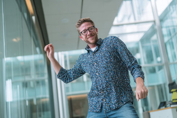 Smiling man dances in modern office, celebrating. Use for web, marketing.