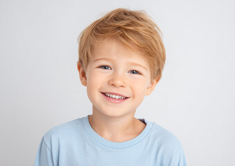 Smiling Boy Portrait: A cheerful kid with blue eyes and light hair smiles. Perfect for advertising, website design, or educational content.