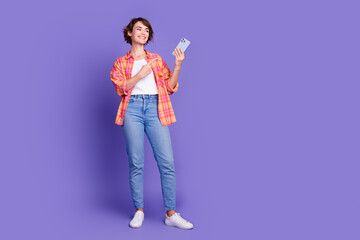 Full length portrait of nice young lady direct finger phone empty space wear shirt isolated on purple color background