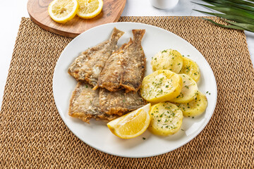Fried sole fish with potatoes and lemon garnish, embracing culinary simplicity