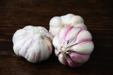Cloves of unpeeled garlic close-up on a dark wooden table