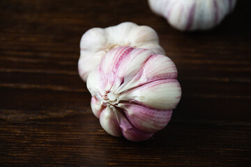 Cloves of unpeeled garlic close-up on a dark wooden table