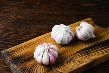 Cloves of unpeeled garlic close-up on a dark wooden table
