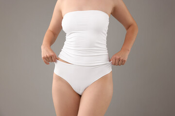 Woman in underwear on grey background, closeup