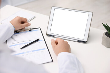 Doctor having online consultation via tablet in clinic, closeup
