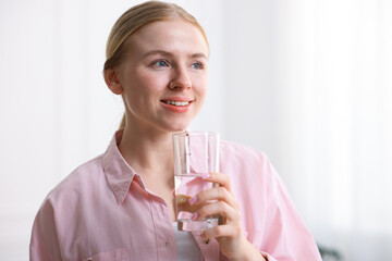 Young woman with glass of water at home