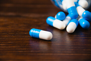 Many pills on a dark background macro. white and blue vitamin pills on a wooden background. Self-medication concept.