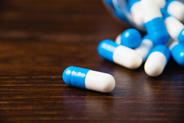 Many pills on a dark background macro. white and blue vitamin pills on a wooden background. Self-medication concept.
