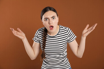 Portrait of surprised woman on brown background