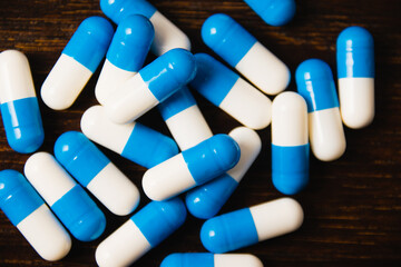 Many pills on a dark background macro. white and blue vitamin pills on a wooden background....