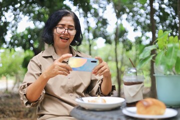 middle-aged woman enjoying coffee and pastry outdoors