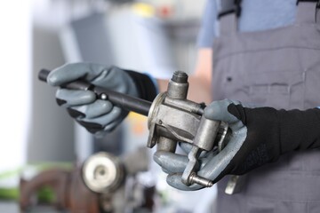 Auto part. Professional mechanic with manual transmission indoors, closeup