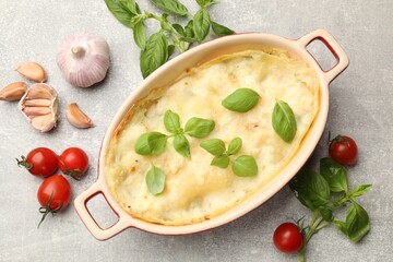 Tasty vegetarian lasagna and ingredients on grey table, flat lay