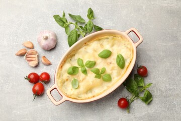 Tasty vegetarian lasagna and ingredients on grey table, flat lay