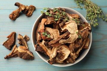 Dried chanterelle mushrooms with thyme on blue wooden table, flat lay