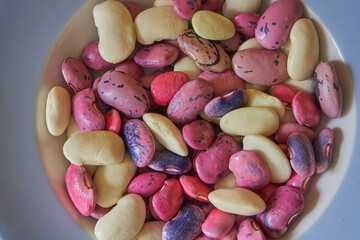 red and white beans in a bowl, a bowl of different types of beans, white beans, pink beans, and purple beans