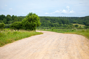 Sand road among green summer hills