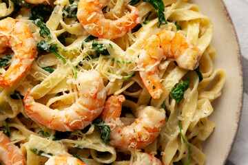 Homemade Creamy One-Pot Spinach Shrimp Pasta on a Plate, top view. Close-up.