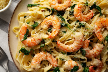 Homemade Creamy One-Pot Spinach Shrimp Pasta on a Plate, top view. Close-up.