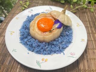 Mini pumpkin stuffed with steamed egg and egg yolk, served with blue rice.