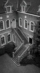 Exterior view of a grand stone mansion with stairs
