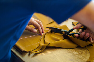 The process of cutting brown material to make clothes