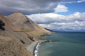 eroded mountain slope above the rugged coastal cliffs, near Fauskasandur, East Iceland