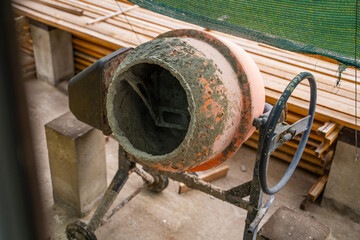 A row of orange concrete mixers on a background of wooden boards