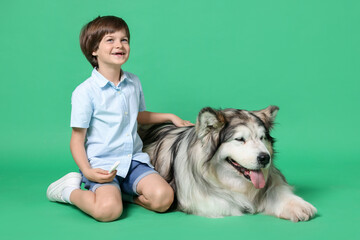 Happy boy and cute dog on green background