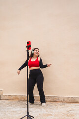Young woman wearing sportswear and headphones recording online dance class using smartphone on...