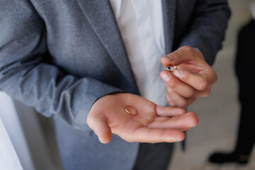 Groom holding wedding ring before ceremony in elegant venue