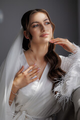 Elegant bride posing in soft light with graceful expression and stylish wedding attire
