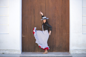 Young woman, beautiful, brunette, flamenco dancer, wearing a beautiful dress with jacket and hat,...