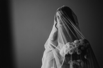 Bridal portrait session featuring a woman in a veil holding roses in a soft setting