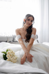Elegant bride with bouquet in a bright indoor setting during pre-wedding preparations