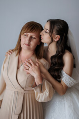 Mother and daughter share a heartfelt moment before the wedding ceremony in a light-filled studio