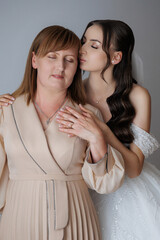 Bride shares a tender moment with her mother before the wedding ceremony