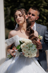 Couple celebrates wedding with intimate moment in beautiful garden on a sunny day